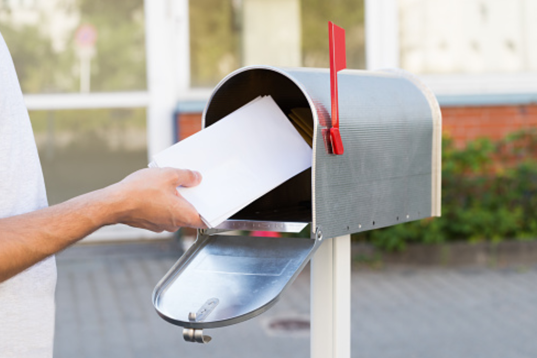 A man puts a letter in a mail box