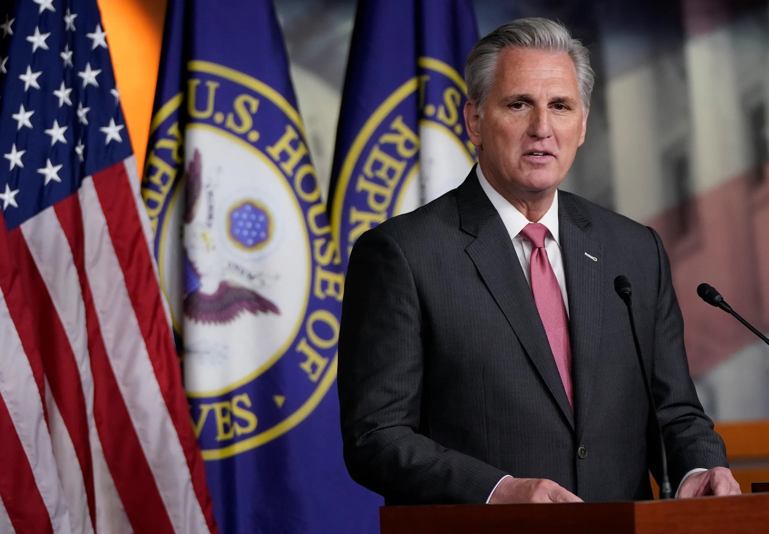 Kevin McCarthy wearing a black suit while speaking on a podium